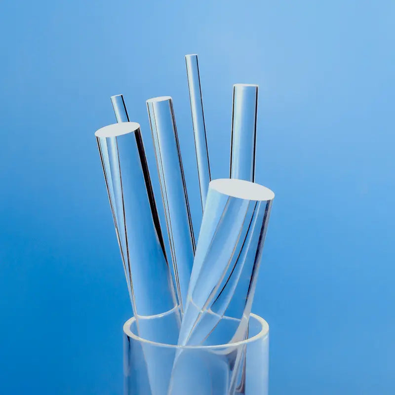 Assortment of clear, high-purity quartz glass rods of various diameters, standing upright in a transparent container