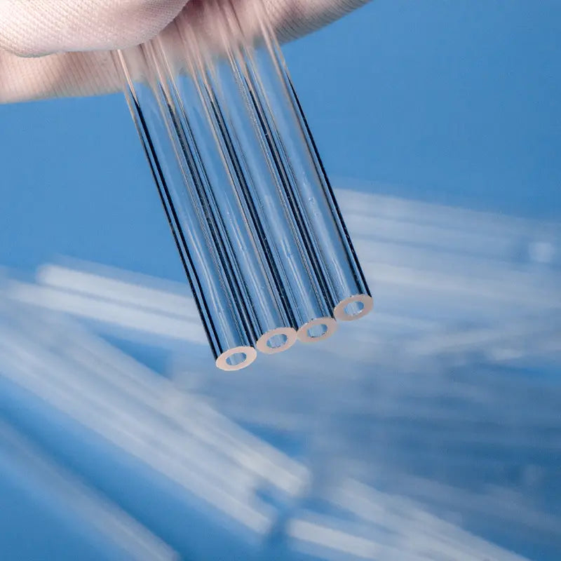 Close-up view of the precisely manufactured ends of four quartz capillary tubes, showing uniform wall thickness.