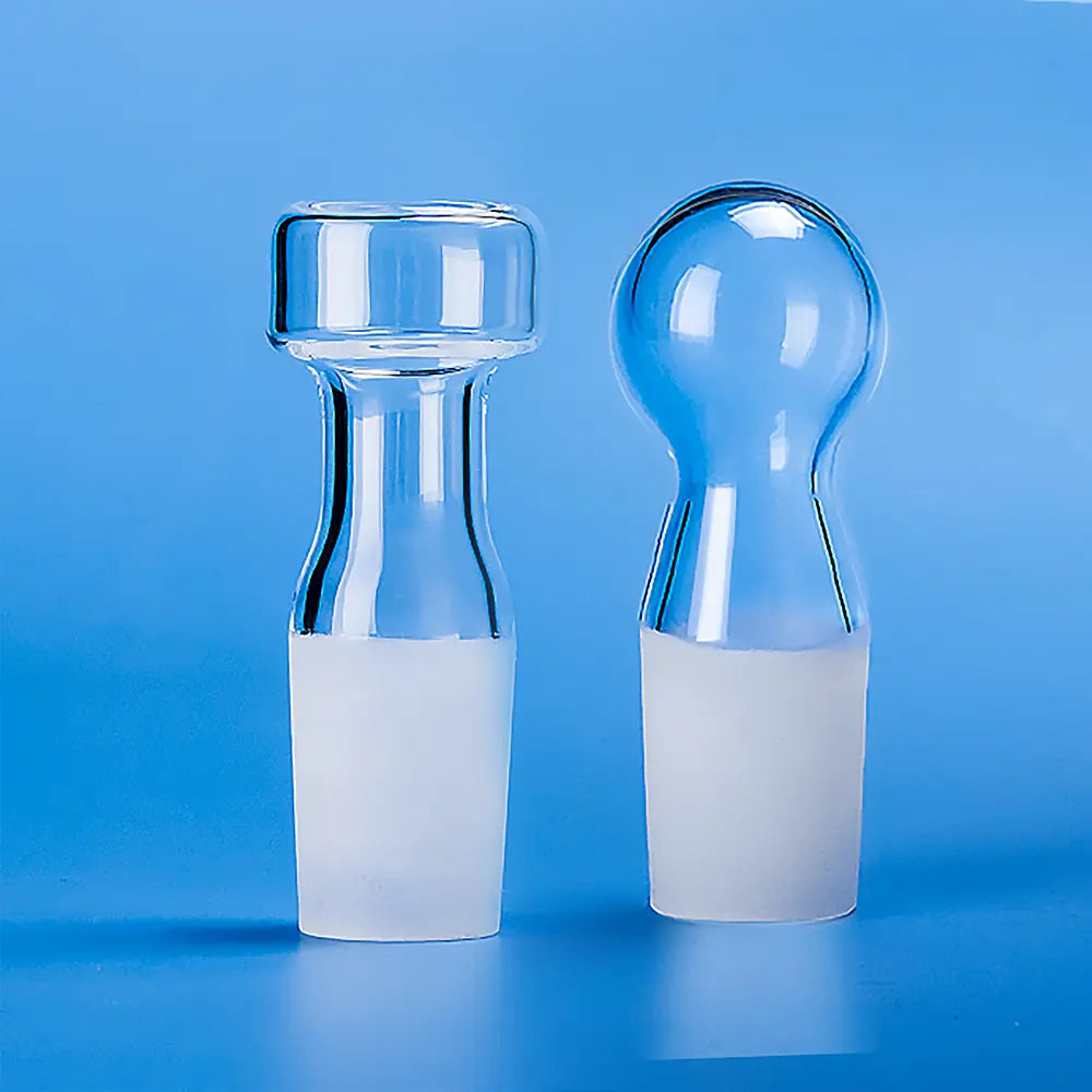 Comparison of a flat head quartz glass stopper and a spherical head quartz glass stopper, both with ground joints.
