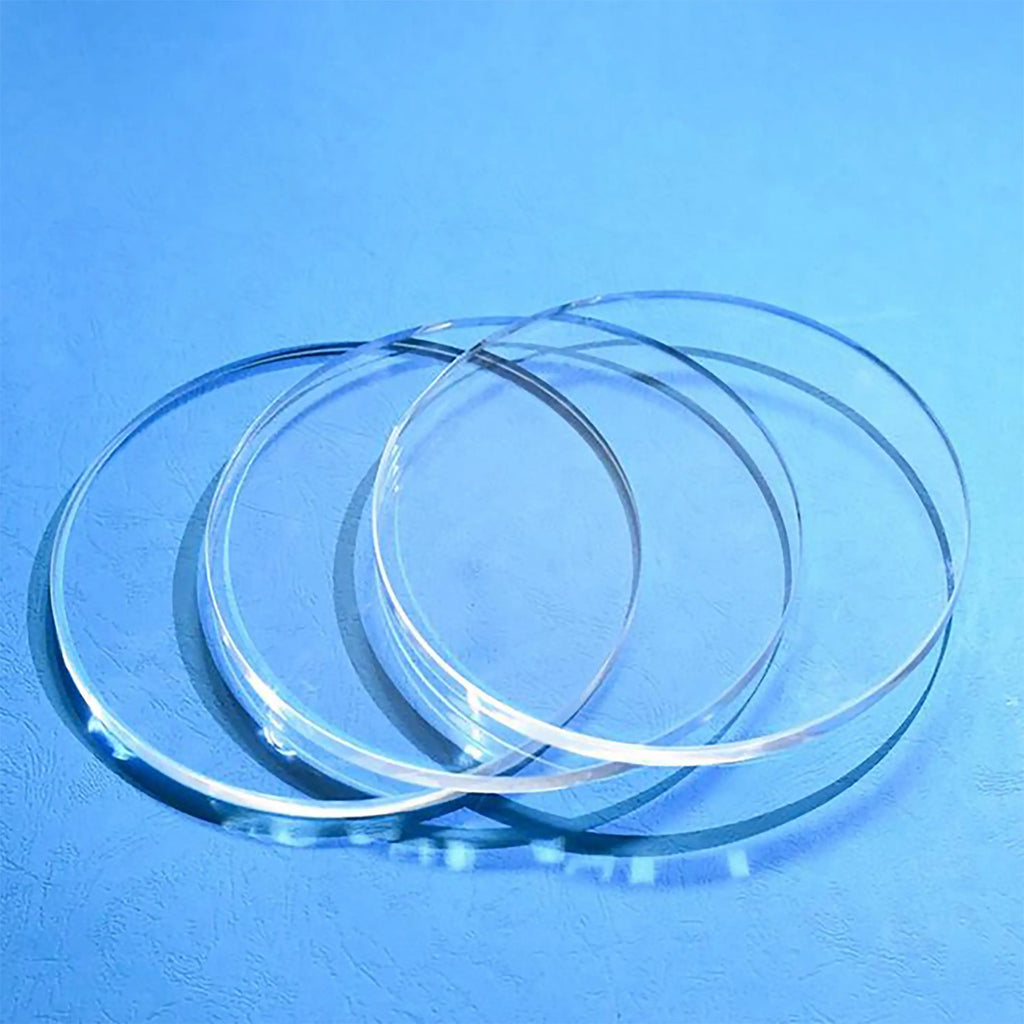 Four high-purity, transparent quartz glass discs, showcasing their smooth edges and optical clarity.