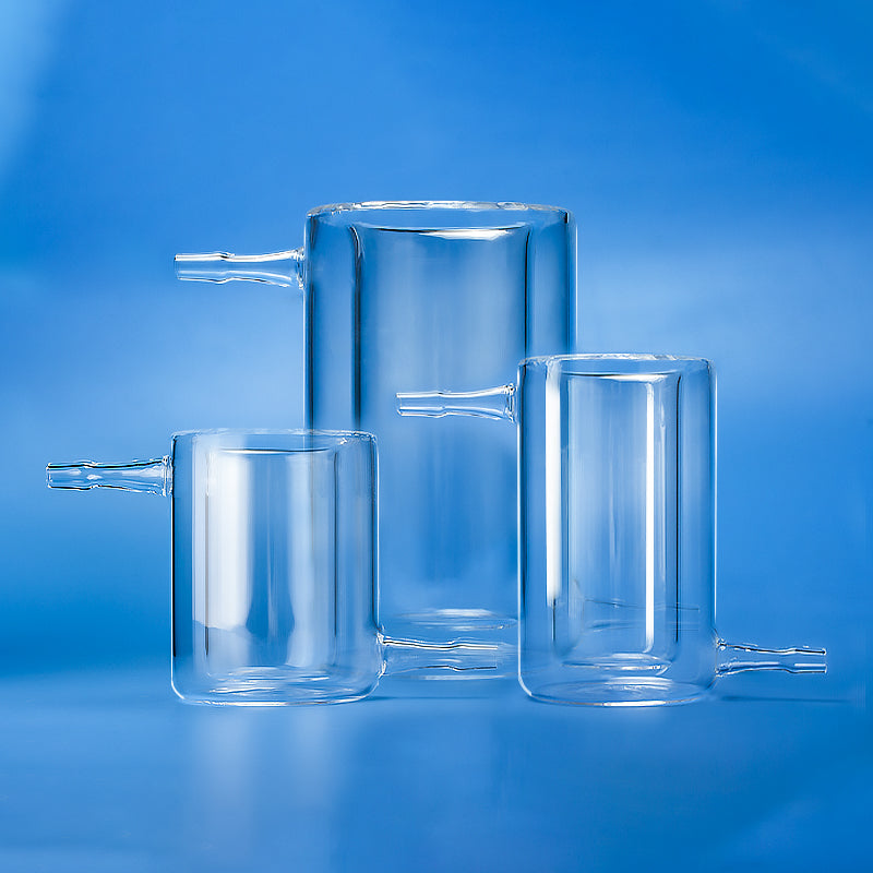 Three different sizes of clear glass double-walled jacketed quartz reactors for laboratory use.