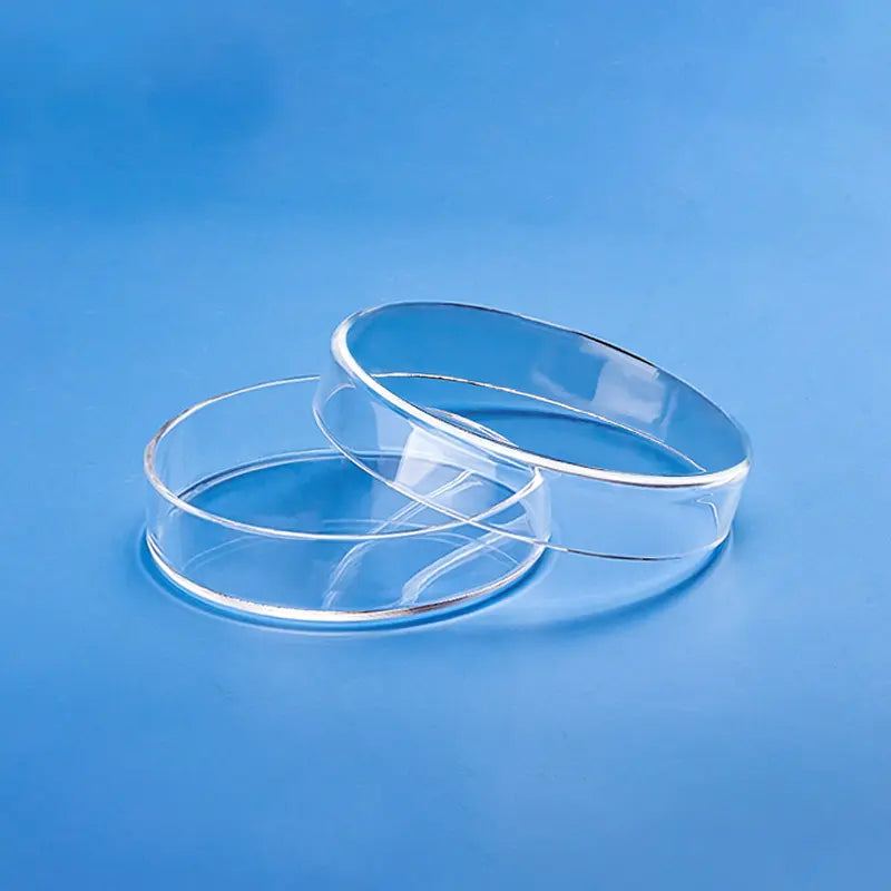 Two clear high-purity quartz glass petri dishes, one nested inside another, on a blue background.